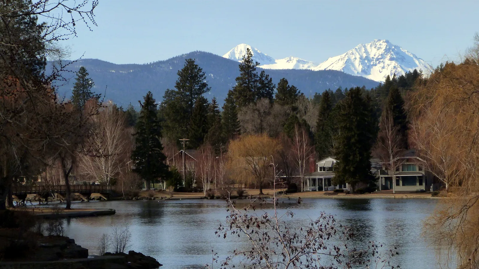 Mirror Pond on the Deschutes River in Bend, with the snowy Middle and North Sister behind the trees