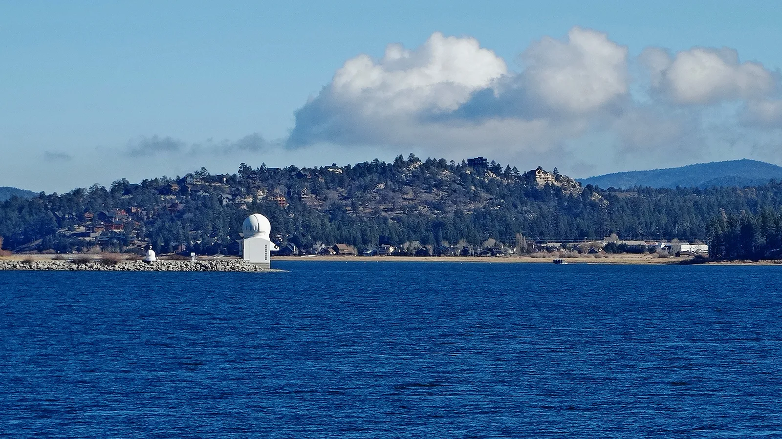 The white dome of the Big Bear Solar Observatory on the north shore, across deep blue water