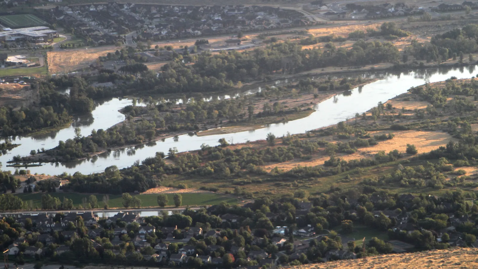 The Boise River and its tree-lined Greenbelt winding through Boise, seen from above