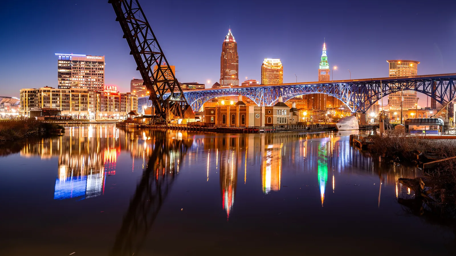 The Cuyahoga River in the Flats at night, with a lift bridge and the downtown skyline