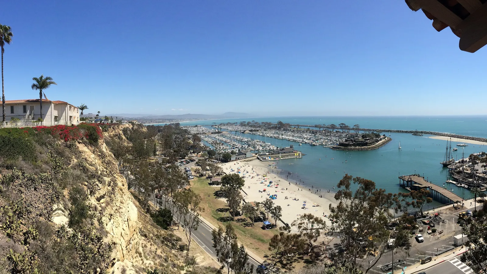 Baby Beach and the west basin of Dana Point Harbor seen from the bluff, with paddlers on the water