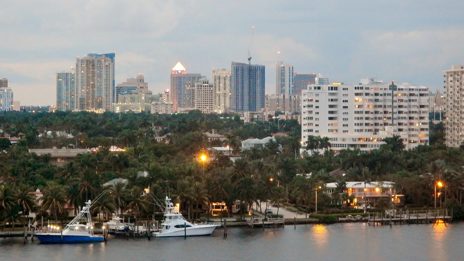 Docks, palms and sportfishing boats on the water near Las Olas, with the downtown skyline behind