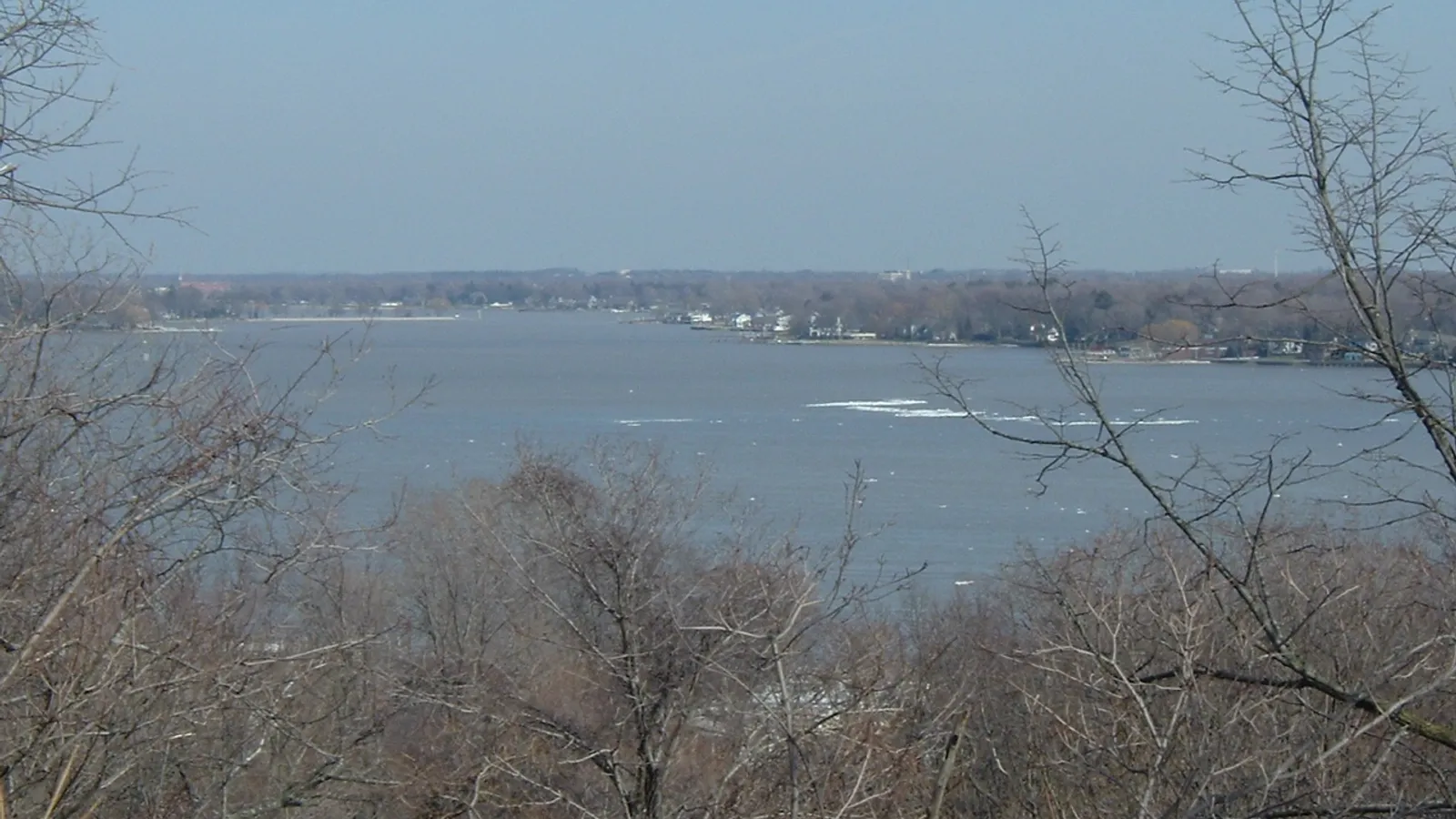 Lake Macatawa seen through bare trees from the dunes above Holland State Park