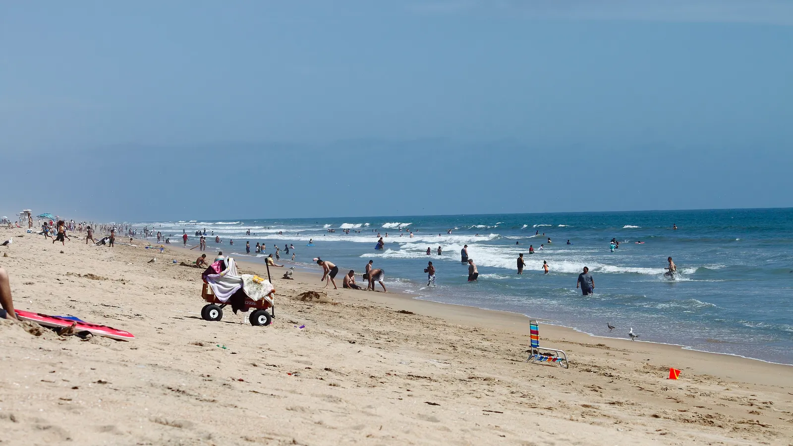 Beachgoers and small surf at Bolsa Chica State Beach, looking south from a lifeguard tower