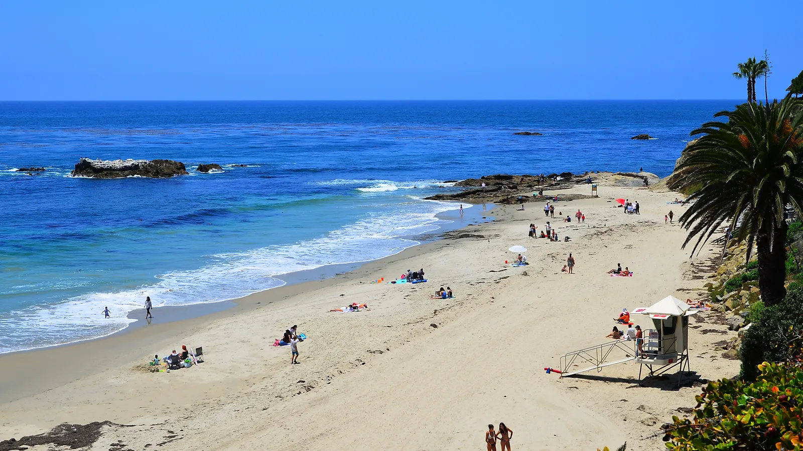 Divers Cove below Heisler Park, with a lifeguard tower on the sand and rocks offshore