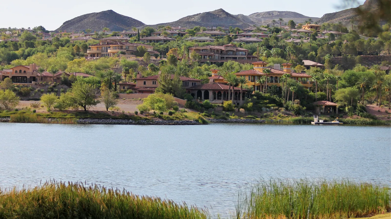 Calm water on Lake Las Vegas with Mediterranean-style homes on the hillside behind