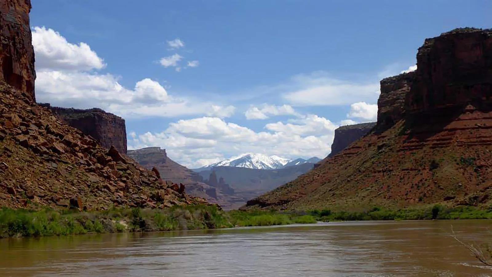 The Colorado River near Fisher Towers, with red cliffs and the snowy La Sal Mountains behind