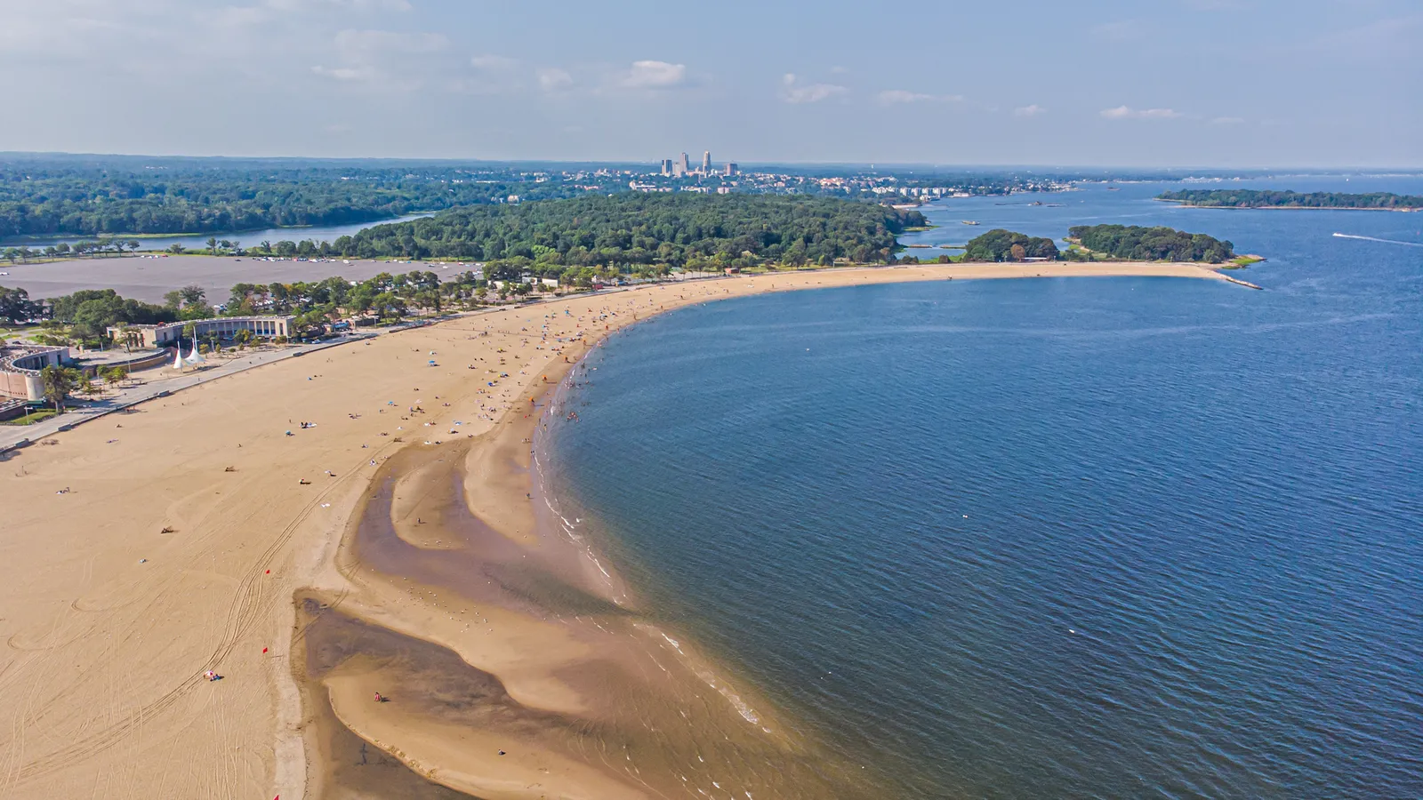 Aerial view of Orchard Beach and the wooded shore of Pelham Bay Park in the Bronx