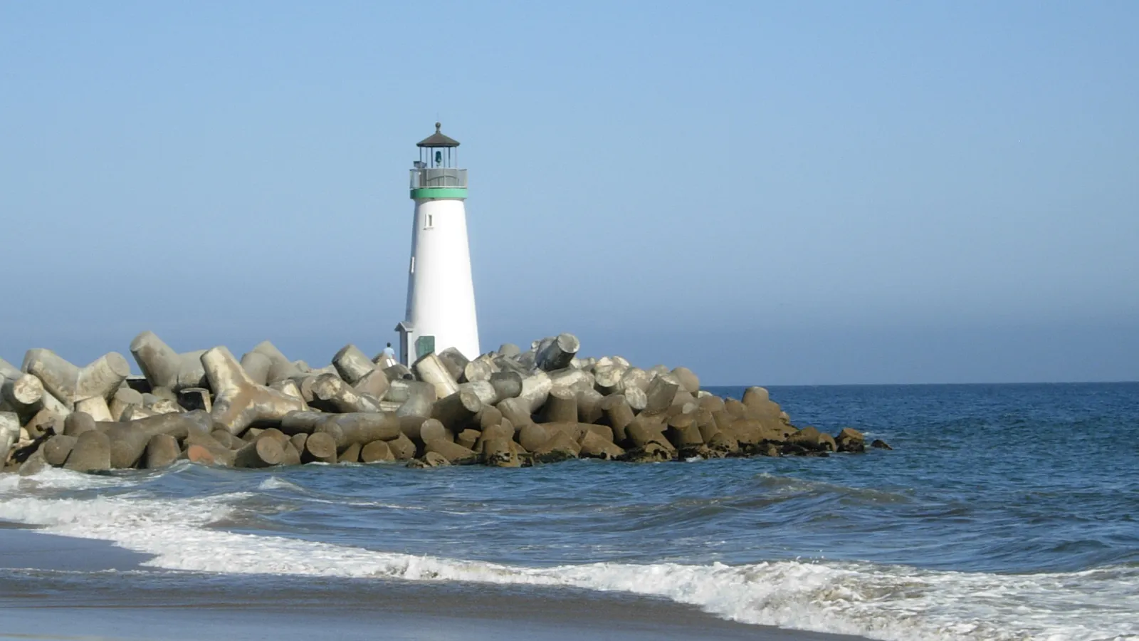 The white Walton Lighthouse on the breakwater at the mouth of Santa Cruz Harbor