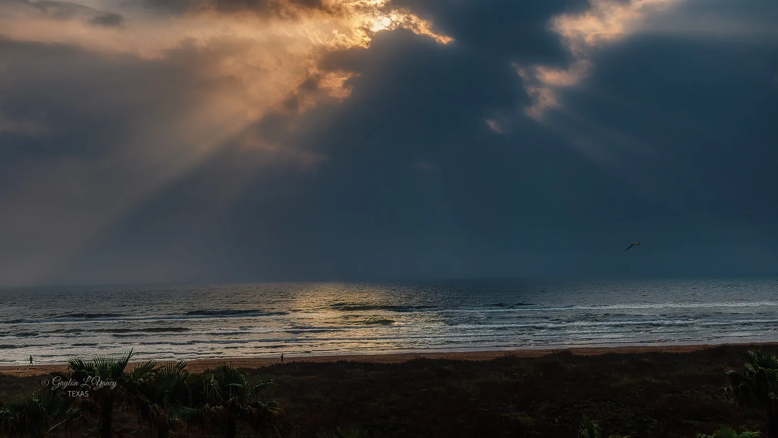 Sunlight breaking through clouds over the Gulf beach at South Padre Island