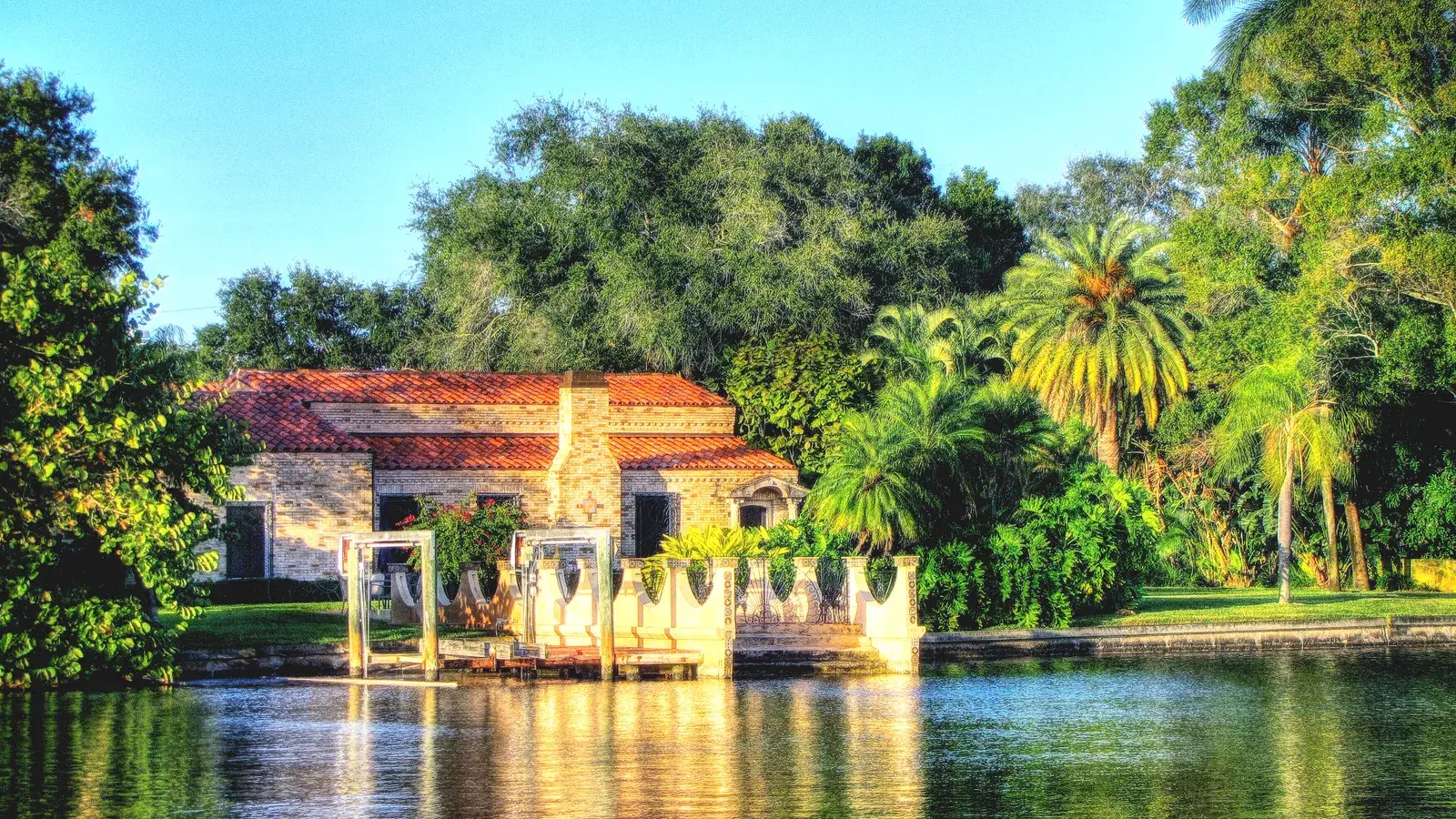A Spanish-style house reflected in the still water of Coffee Pot Bayou on Snell Isle