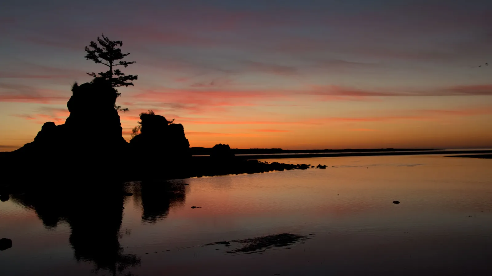 Rocks silhouetted at sunset on Siletz Bay