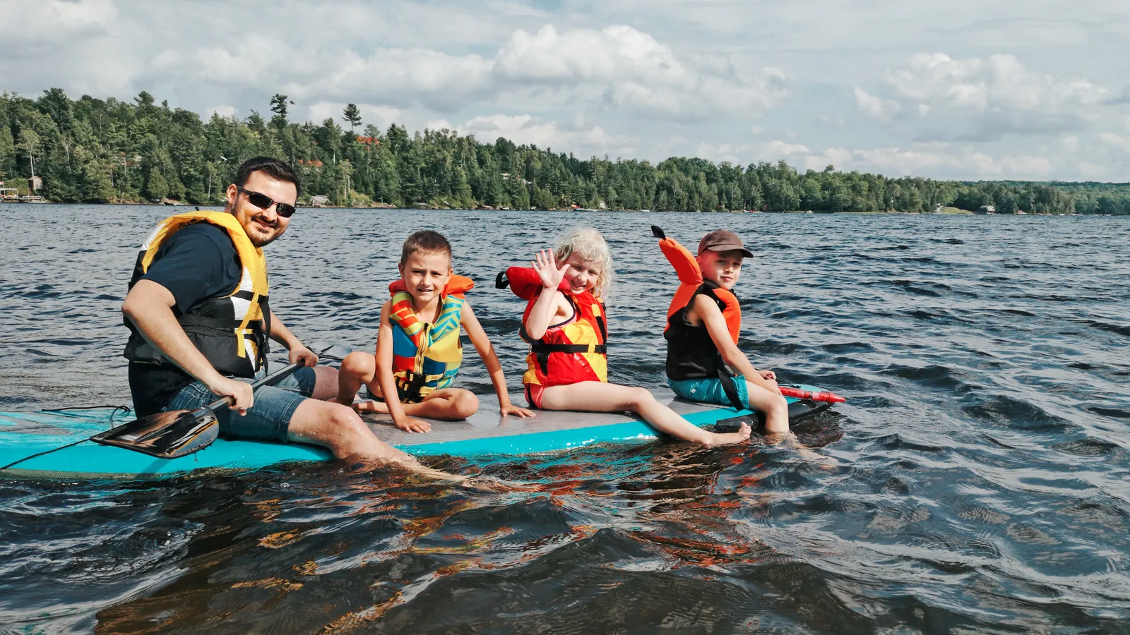 People sitting and paddling on paddle boards